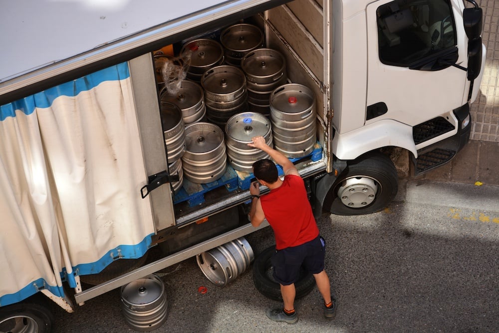 Guy unloading kegs stock